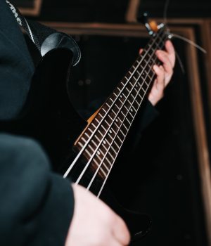 close-up-musician-guitarist-playing-bass-guitar-strings-indoors-selective-focus.jpg